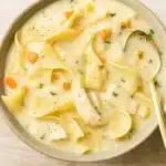 Creamy Chicken Noodle Soup in a rustic kitchen setting