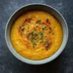 One Pot Creamy Carrot Lentil Soup in a bowl with garnish