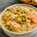 Slow Cooker Chicken Pot Pie with biscuits on table