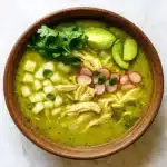 Crockpot Mexican Chicken Pozole Verde Recipe in a bowl with lime and cilantro