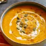 Panera Autumn Squash Soup served in a bowl with pepitas and cream