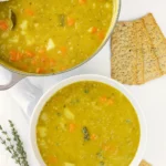 Classic split pea soup in rustic bowl with herbs