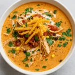 creamy chicken enchilada soup in bowl with toppings