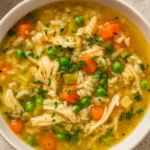 Crockpot Chicken and Rice Soup in a bowl with fresh herbs