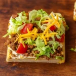 Easy Crescent Roll Taco Pizza on wooden table with toppings