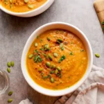 Pumpkin and Sweet Potato Soup in rustic bowl with thyme