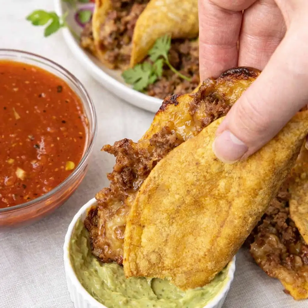 Crispy baked beef tacos fresh from the oven with cheese and toppings