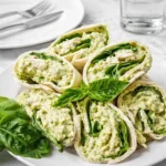 Simple pesto chicken salad served in a bowl with croissants