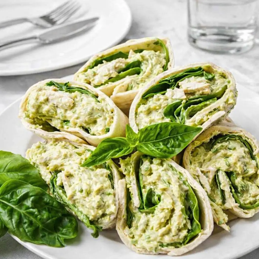 Simple pesto chicken salad served in a bowl with croissants